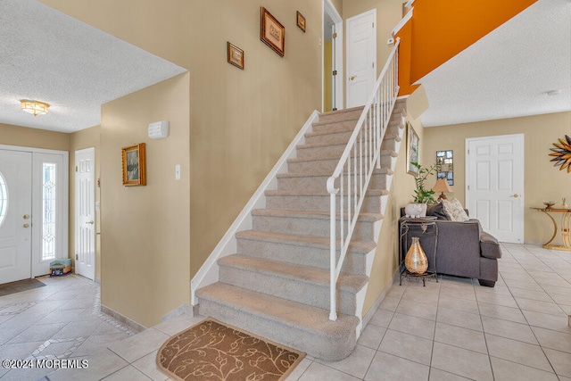 tiled entrance foyer featuring a textured ceiling