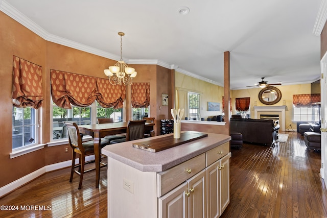 kitchen featuring dark wood-type flooring, plenty of natural light, a center island, and crown molding