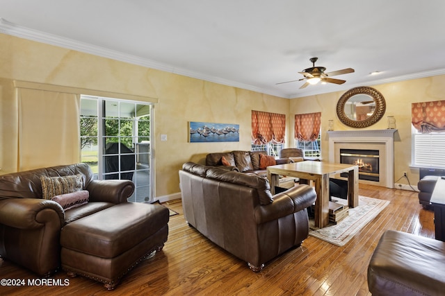 living room featuring crown molding, light hardwood / wood-style flooring, and ceiling fan