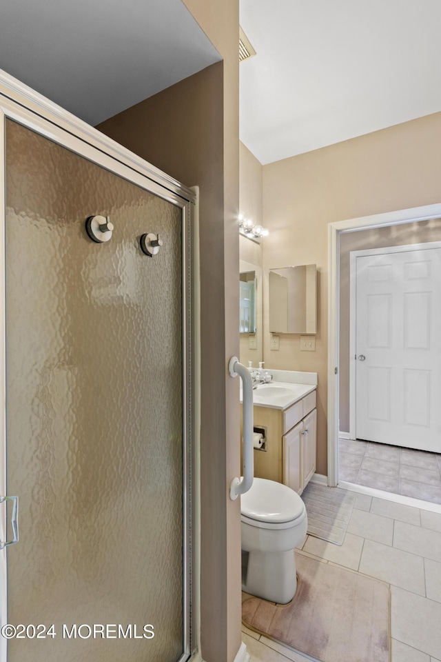 bathroom featuring tile patterned flooring, walk in shower, and vanity