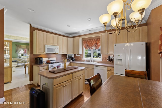 kitchen featuring white appliances, light brown cabinetry, sink, light hardwood / wood-style flooring, and pendant lighting