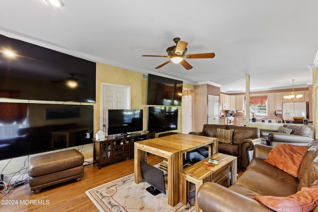 living room with ceiling fan with notable chandelier, light hardwood / wood-style flooring, and ornamental molding