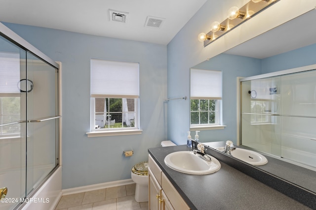 full bathroom with combined bath / shower with glass door, toilet, tile patterned flooring, and vanity