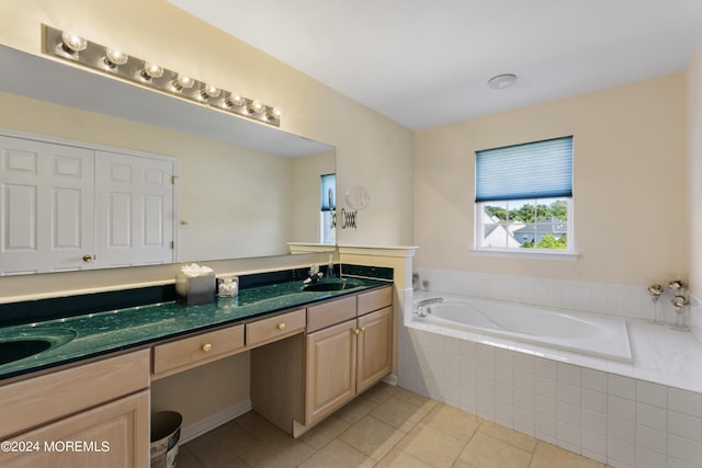 bathroom featuring vanity, tiled tub, and tile patterned floors