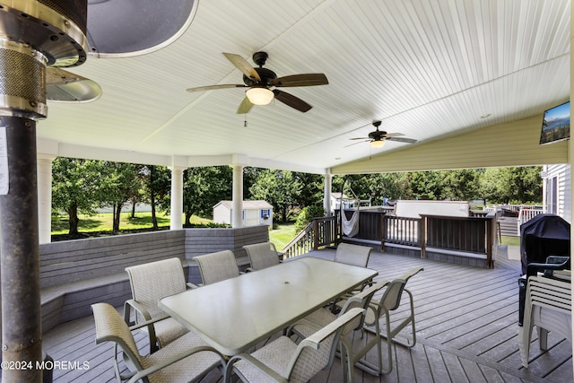 wooden deck featuring ceiling fan and a storage unit