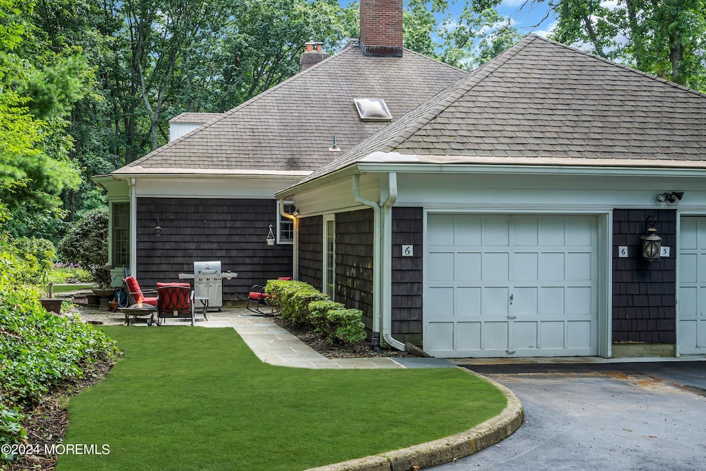 back of house featuring a garage, central AC, and a yard