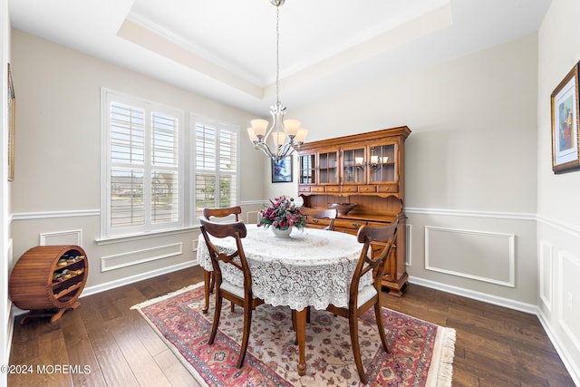 dining room with crown molding, an inviting chandelier, dark hardwood / wood-style floors, and a raised ceiling