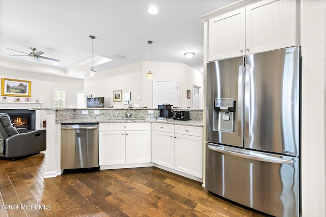 kitchen featuring light stone counters, white cabinets, hanging light fixtures, and appliances with stainless steel finishes