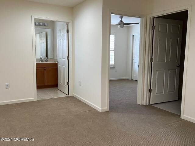 hallway featuring light colored carpet and sink