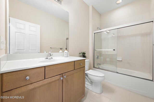 full bathroom with vanity, toilet, enclosed tub / shower combo, and tile patterned floors