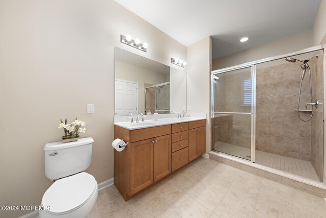 bathroom with tile patterned floors, toilet, a shower with door, and vanity