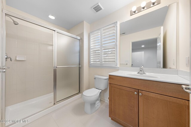 bathroom with toilet, tile patterned flooring, walk in shower, and vanity