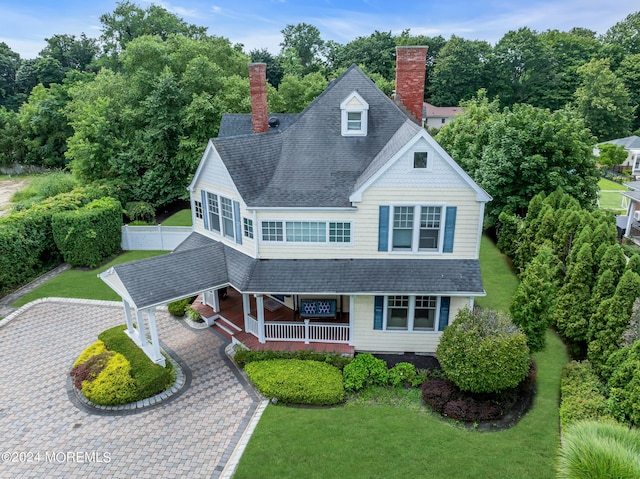 view of front of home with a carport, a front yard, and covered porch