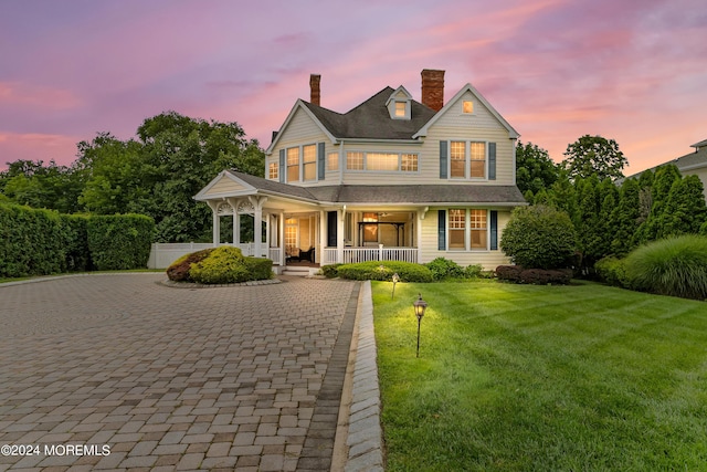 view of front of property featuring a lawn and a porch