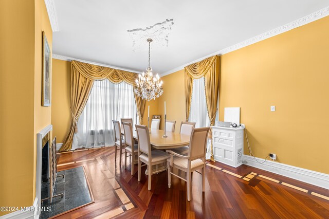 dining room with wood-type flooring, ornamental molding, and a notable chandelier