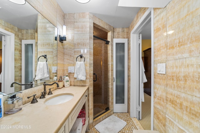 bathroom with vanity, an enclosed shower, tile patterned flooring, and tile walls