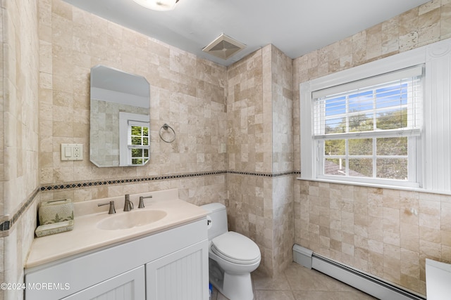 bathroom with a baseboard radiator, vanity, toilet, and tile walls