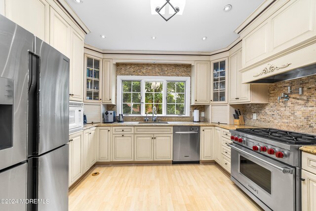 kitchen featuring sink, cream cabinetry, light wood-type flooring, and stainless steel appliances