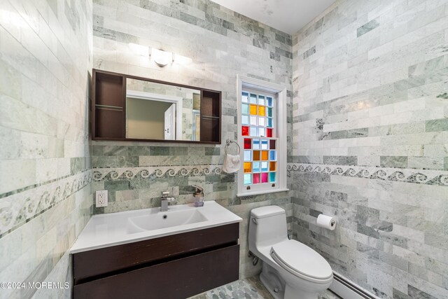 bathroom featuring vanity, toilet, and tile walls