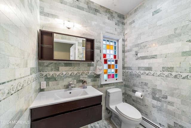 bathroom with tile walls, vanity, a baseboard radiator, and toilet