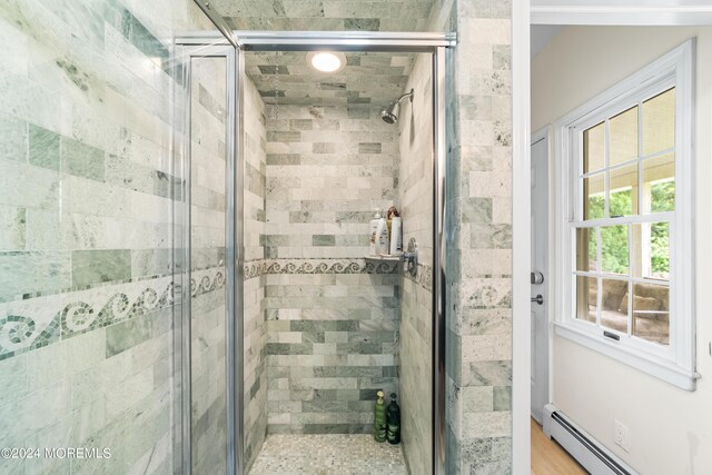 bathroom featuring walk in shower and baseboard heating