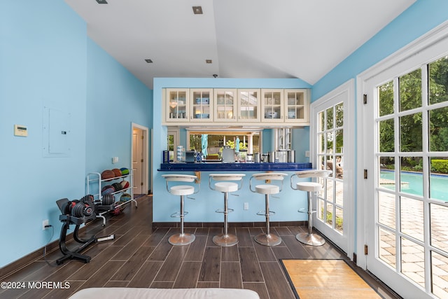 bar featuring white cabinetry, electric panel, and high vaulted ceiling