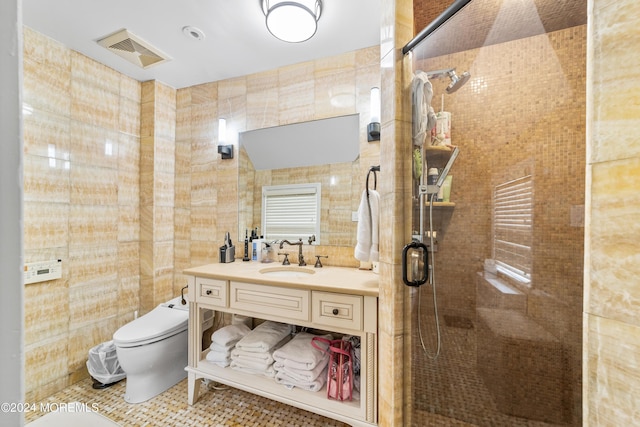 bathroom with toilet, an enclosed shower, tile walls, vanity, and tile patterned flooring