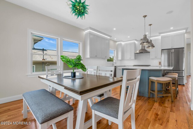 dining space with a healthy amount of sunlight, light hardwood / wood-style flooring, and sink