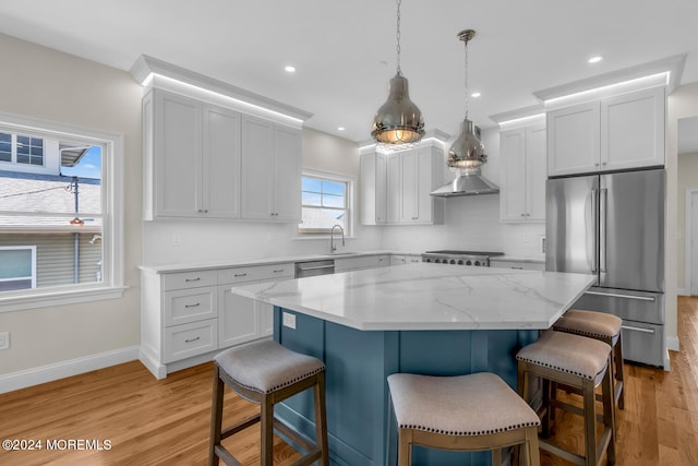 kitchen with a center island, appliances with stainless steel finishes, light hardwood / wood-style flooring, and hanging light fixtures