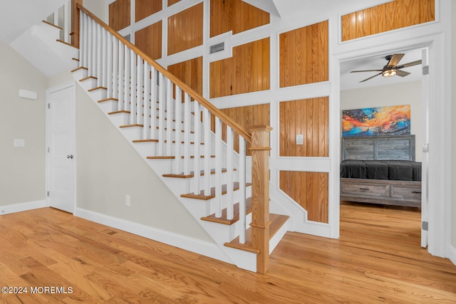 stairs featuring light hardwood / wood-style flooring and ceiling fan