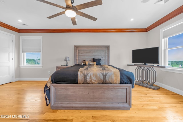 bedroom featuring multiple windows, light wood-type flooring, ceiling fan, and ornamental molding