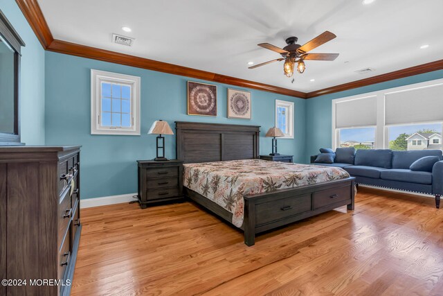 bedroom with light hardwood / wood-style floors, ornamental molding, and ceiling fan