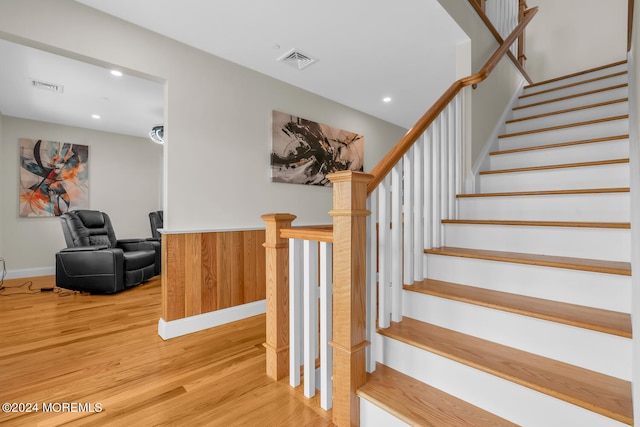 stairs with a wainscoted wall, wood finished floors, visible vents, and recessed lighting