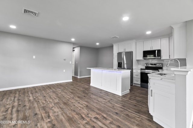 kitchen featuring a center island, sink, stainless steel appliances, white cabinets, and dark hardwood / wood-style flooring