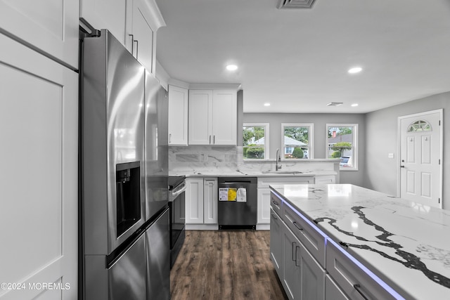 kitchen featuring stainless steel appliances, white cabinetry, tasteful backsplash, and sink