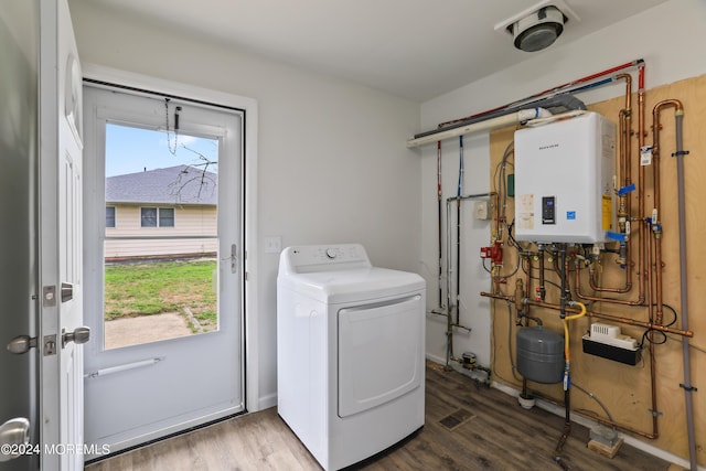 laundry area featuring washer / dryer, tankless water heater, and hardwood / wood-style floors