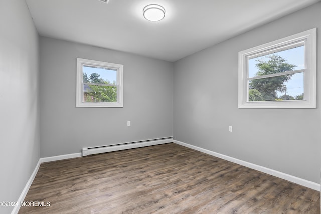 spare room featuring dark hardwood / wood-style flooring and a baseboard radiator