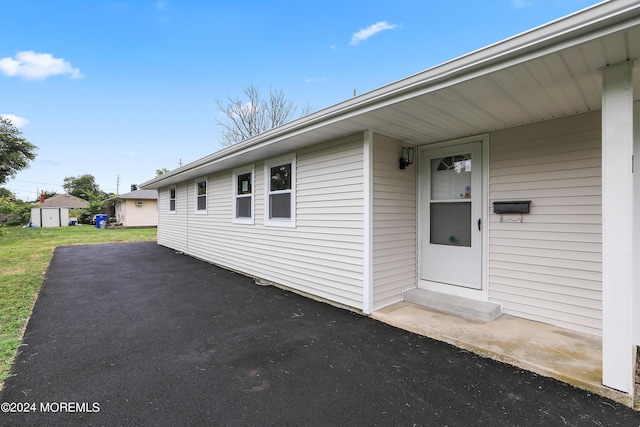 entrance to property featuring a patio area and a yard