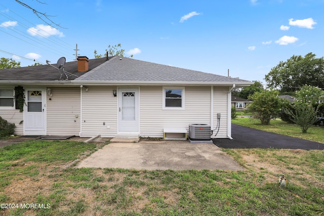 back of house with central AC unit, a patio area, and a yard