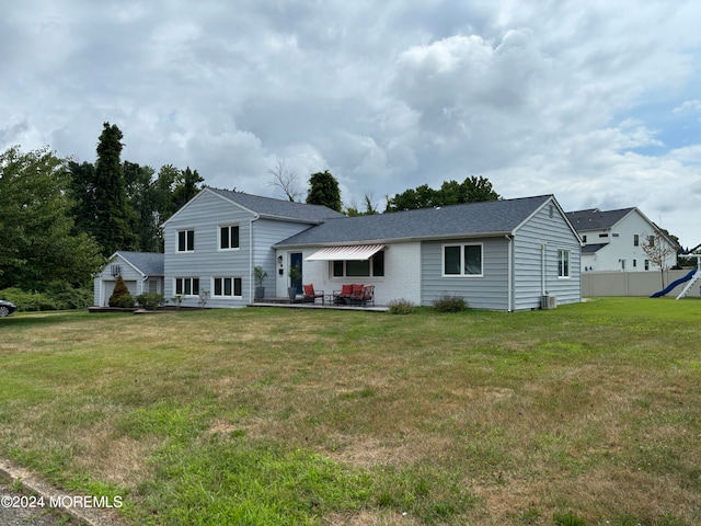 rear view of house featuring a lawn