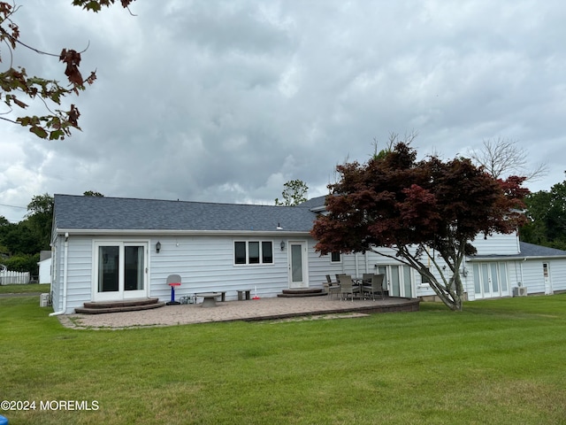 back of house with a patio area and a lawn