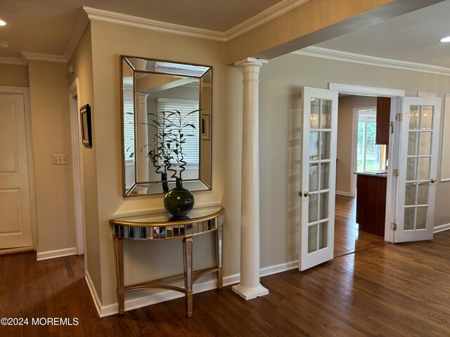 hall with crown molding, decorative columns, and dark wood-type flooring