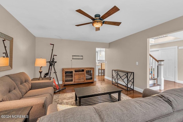 living room featuring wood-type flooring and ceiling fan