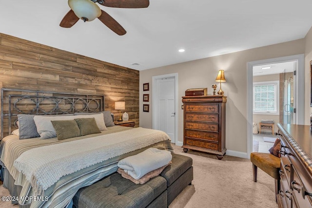 carpeted bedroom featuring ceiling fan and wood walls