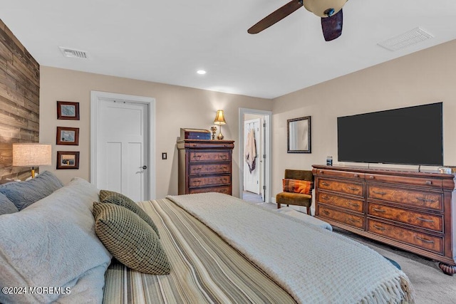 bedroom with wooden walls, ceiling fan, and carpet flooring