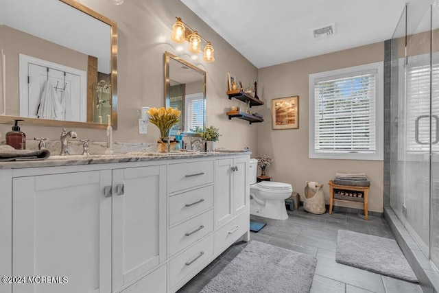 bathroom with vanity, a shower with shower door, and toilet