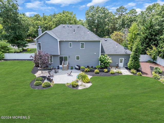 back of property with a yard and a patio