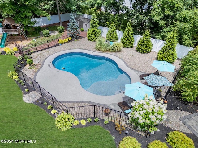 view of swimming pool featuring a yard and a playground