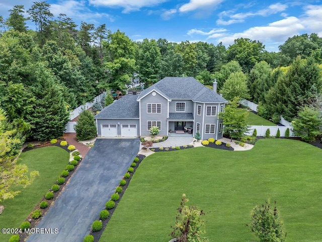 view of front of house featuring a porch, a garage, and a front lawn