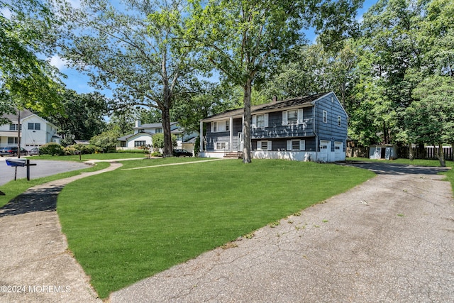 raised ranch with aphalt driveway and a front yard